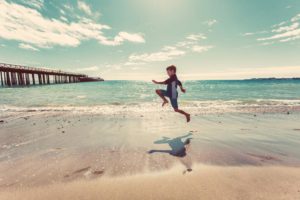 Child development. Boy jumping on a beach