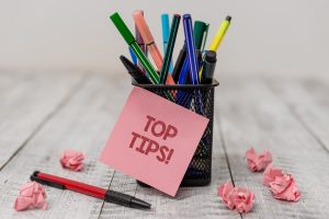 Top tips post-it note on pens on a table