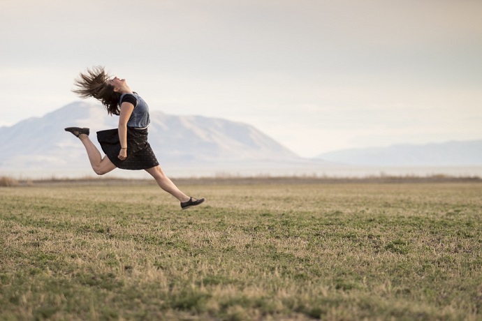 Motivational quotes. Woman jumping in the air.