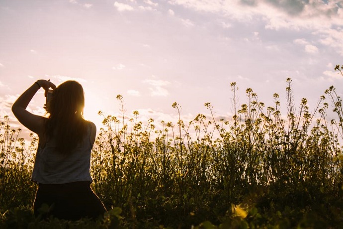 Start working in a creative job. Woman taking photo in a field