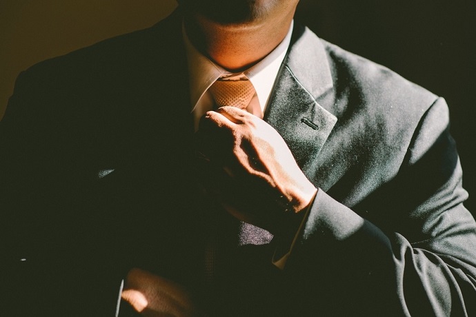 Security manager jobs. Man putting on a tie