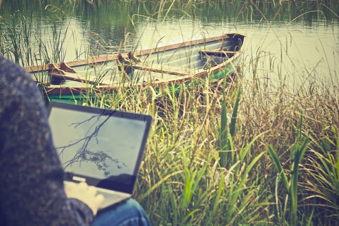 Study space. Using a laptop by a river