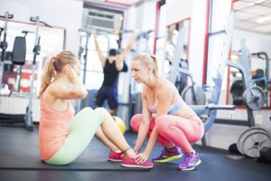 How to become a personal trainer. Two women working out in a gym