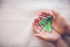 Hands holding a mental health awareness ribbon