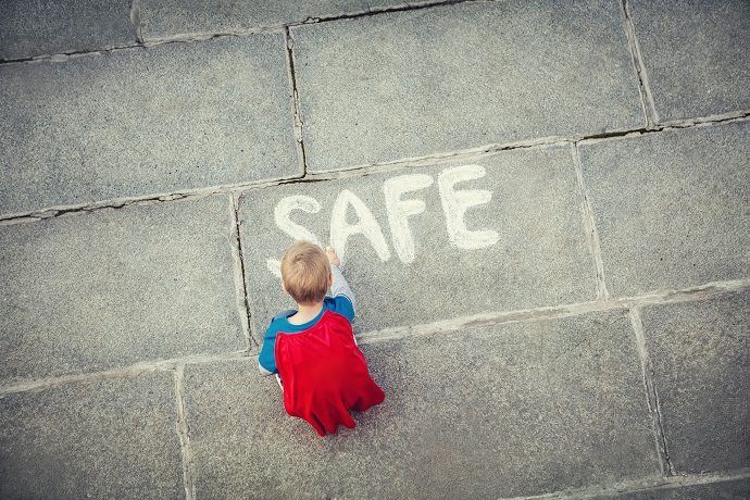 Little boy draws inscription outdoors, social worker